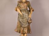 statue d'une femme tenant un panier de fleurs à la main