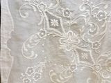 a close up of a piece of white linen with embroidery on it