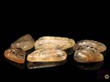 four pieces of carved soap sitting on top of a black surface