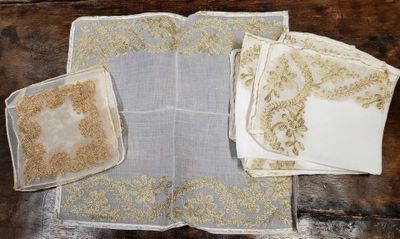 plusieurs morceaux de tissu ornés de motifs dorés, posés sur une table en bois