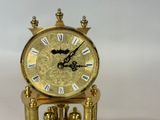a gold clock that is sitting on top of a table