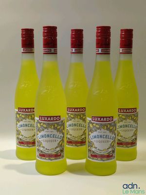 quatre bouteilles de limonade sont alignées sur une surface blanche