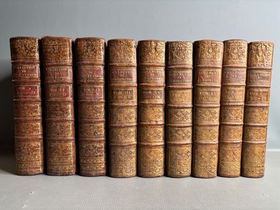 several old books are lined up in a row on a table