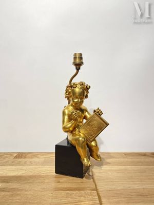 une image représentant une statue en or d'un enfant tenant un livre