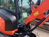 the back end of a red and black tractor parked in a parking lot