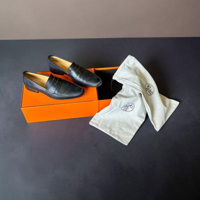 une paire de chaussures en cuir noir dans une boîte recouverte d'un tissu blanc