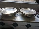 deux plateaux en argent posés sur un comptoir devant une fenêtre