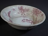 a white bowl with a red floral design on it