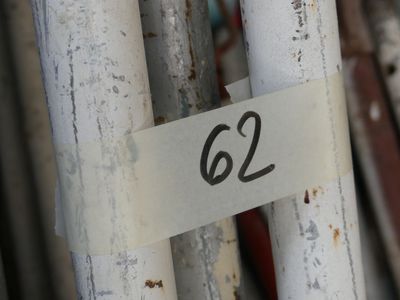 un panneau sur lequel est inscrit « 62 » sur le côté d'une clôture blanche