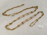 a close up of a gold chain with a tag on it