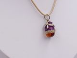 necklace with a purple and orange glass bead on a white mannequin