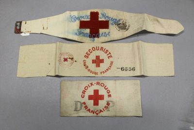 three medical bracelets with a red cross on them on a table