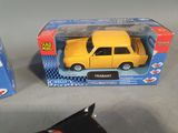 a yellow toy car in a box next to another toy car