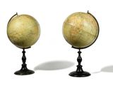 trois globes anciens empilés les uns sur les autres sur une surface blanche