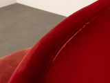 the back of a red chair in a room with a gray floor