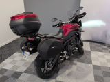 a red motorcycle parked in a room with a checkered floor