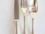three forks, a knife, and a spoon on a table
