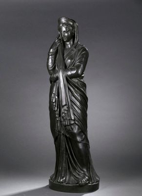 une statue en bronze représentant une femme vêtue d'une robe drapée