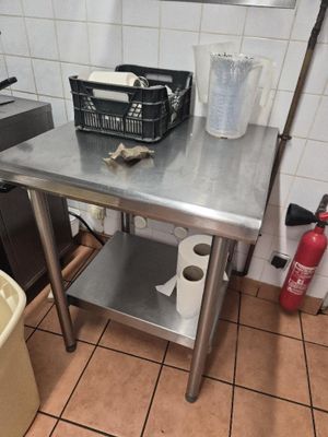 stainless steel work table in a commercial kitchen with a fire extinguisher in the background