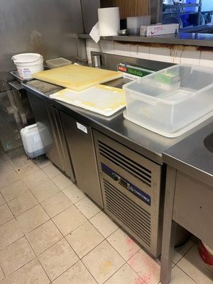 plan de travail en acier inoxydable dans une cuisine professionnelle, équipé d'un évier et d'un lave-vaisselle