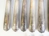 six cuillères et une fourchette sont alignées sur une table