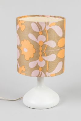 un gros plan d'une lampe posée sur une table, avec un pied blanc