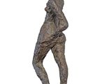 statue of a man standing on a rock with his hands in his pockets