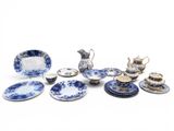 several pieces of blue and white china on a white surface