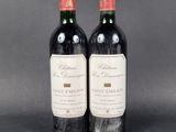 two bottles of wine sitting next to each other on a table