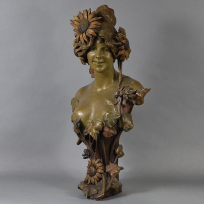 a bronze busturine of a woman with flowers on her head