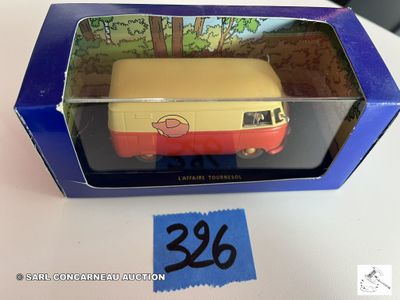 une boîte contenant un petit bus en jouet, posée sur une table