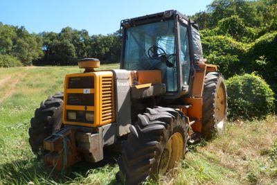 un tracteur qui est à l'arrêt dans l'herbe
