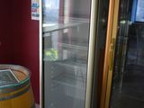 a wine cooler sitting next to a wooden barrel in a room