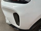 a close up of a white car parked in a parking lot