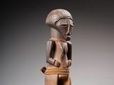 une image représentant une statue en bois d'un homme tenant un panier