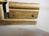 an old brass stapler sitting on top of a white table