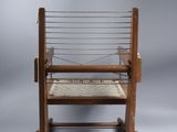an old wooden chair with a woven seat on a gray background