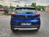 the rear end of a blue car parked on the side of a road