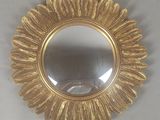 un miroir rond orné d'un motif à la feuille d'or