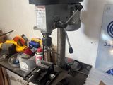 a drill on a table in a room with a lot of clutter