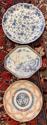 several plates are lined up on a rug on the floor