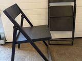 a black chair and a black chair next to a white wall