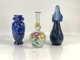 three different colored vases sitting next to each other on a white surface