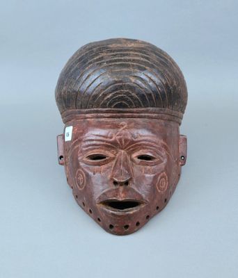gros plan d'un masque en bois sur une surface blanche