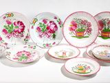 de nombreuses assiettes et bols décorés de fleurs, posés sur une table