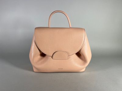 beige leather handbag on grey background with a small handle