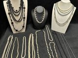 many necklaces and bracelets on display on a table