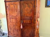 a large wooden armoire in a room with a painting on the wall