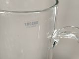 a clear glass cup with a handle on a table