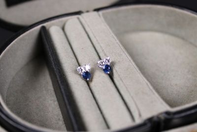 a pair of blue and white diamond earrings in a case